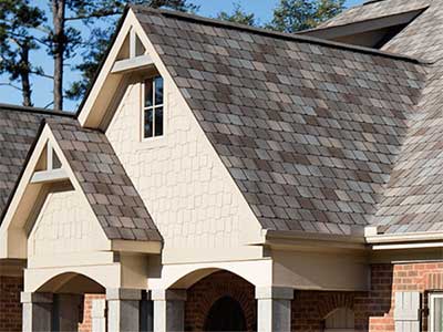 Mid-class home with a variety of colored Atlas shingles on its roof ranging from gray to brown
