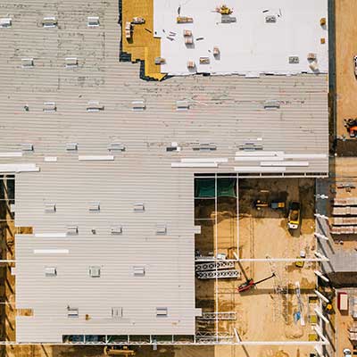 Top view of a flat commercial roof getting a new white TPO system installed